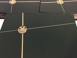 quatre classeurs noirs avec des bordures dorées et une couronne sur la couverture
