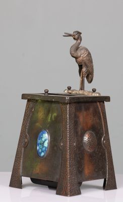 une statue en bronze représentant un oiseau perché sur une table