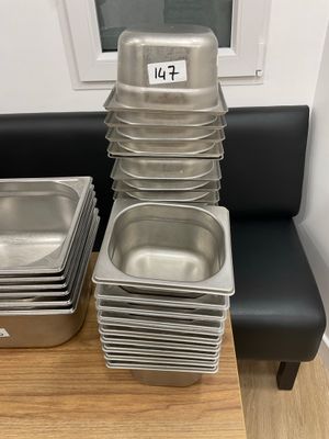 many trays of food sitting on a table next to a window