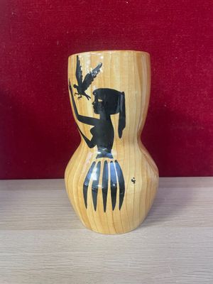a wooden vase with a picture of a woman and a bird on it