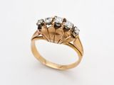 gros plan d'une bague en or ornée de trois diamants