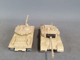 two toy tanks sitting next to each other on a table