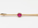 un lingot d'or orné d'une pierre rose