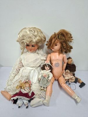 two dolls sitting next to each other on a table