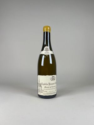 une vieille bouteille de vin posée sur une table blanche