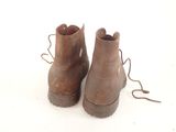 pair of brown leather boots with laces on them on a white surface