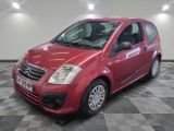 la petite voiture rouge est garée sur un sol en damier
