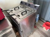 une photo d'une friteuse professionnelle posée sur un plancher en bois