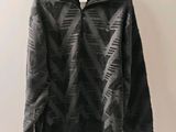 un pull noir accroché au mur à côté d'un cintre