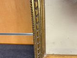 a picture of a gold framed mirror on the floor
