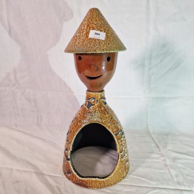 a ceramic figurine of a man with a hat on his head