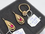 trois paires de boucles d'oreilles en or et rubis présentées dans un écrin noir