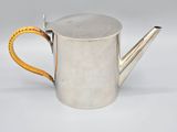 an old silver watering can with a yellow handle on a white background