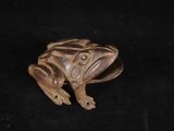 un gros plan d'une figurine de grenouille sur fond noir