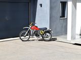 a red motorcycle parked in front of a garage