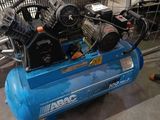 a blue air compressor sitting on a cart in a garage