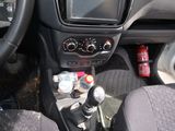 a car dashboard with a steering control and a bottle of soda