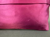 a close up of a pink clutch bag on a table