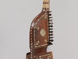 wooden musical instrument hanging from a rope on a gray background