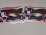 trois cartons contenant des trains miniatures posés sur une table