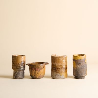 trois petites tasses posées les unes à côté des autres sur une surface blanche