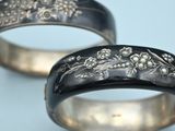 pair of wedding rings with engraved designs on them on a blue background