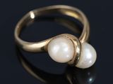 a close up of a gold ring with two pearls on it