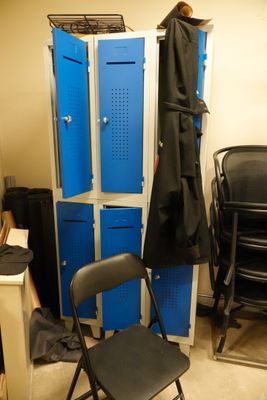 an image of a room with blue lockers and a chair