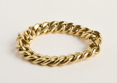 une image d'un bracelet en or sur fond blanc
