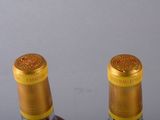 two bottles of wine sitting next to each other on a table