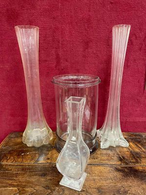trois vases posés sur une table en bois, sur fond rouge