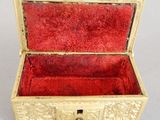 a small gold box with a red velvet lining