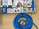 un tuyau bleu posé par terre à côté d'une caisse à outils