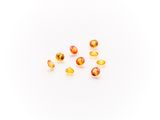 a group of yellow and orange gems on a white surface