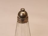 une petite salière et poivrière en verre posées sur une table