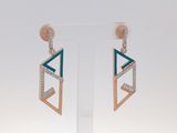 une paire de boucles d'oreilles ornées de diamants bleus et blancs, montées sur une tige transparente
