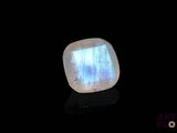 a close up of a white and blue stone on a black surface