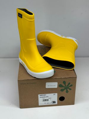 une paire de bottes de pluie jaunes posée sur une boîte en carton
