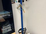 a coat rack with a coat hanger on it in the corner of a room