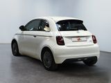 the small white car is parked in a large room
