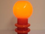 an orange lamp that is sitting on a table