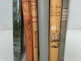 several books are lined up in a row on a white surface