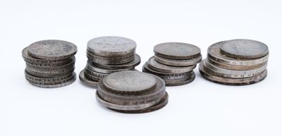 several stacks of coins sitting on top of each other on a white surface