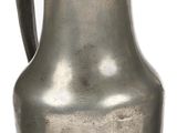 a silver pitcher sitting on a white surface