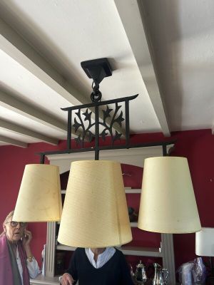 un homme debout devant un lustre muni de trois lampes