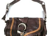 porte-monnaie en cuir marron orné d'une boucle métallique sur fond blanc