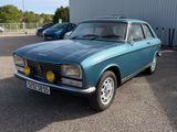 une voiture bleue garée dans un parking à côté d'un bâtiment
