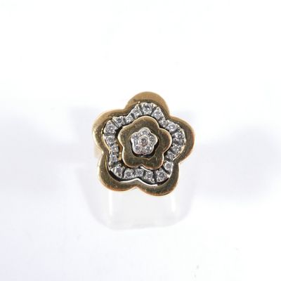 un gros plan d'une bague en or ornée d'une fleur en diamant