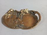 a gold plate with flowers on it on a white surface
