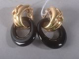 pair of black and gold earrings on a white surface